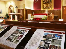 Posters describing Eucharistic miracles are displayed in pews at St. Edmund’s Church.
